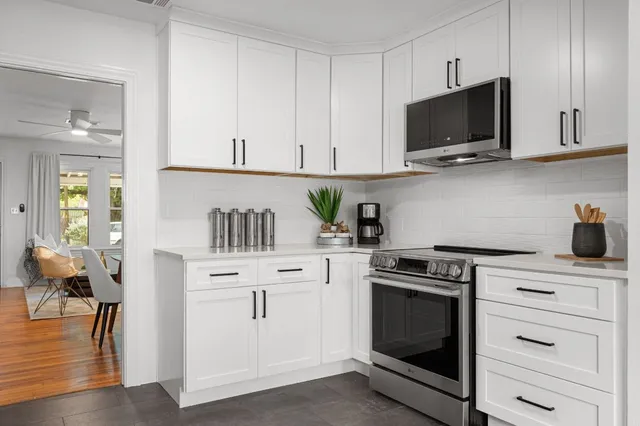 a kitchen with white cabinets and appliances