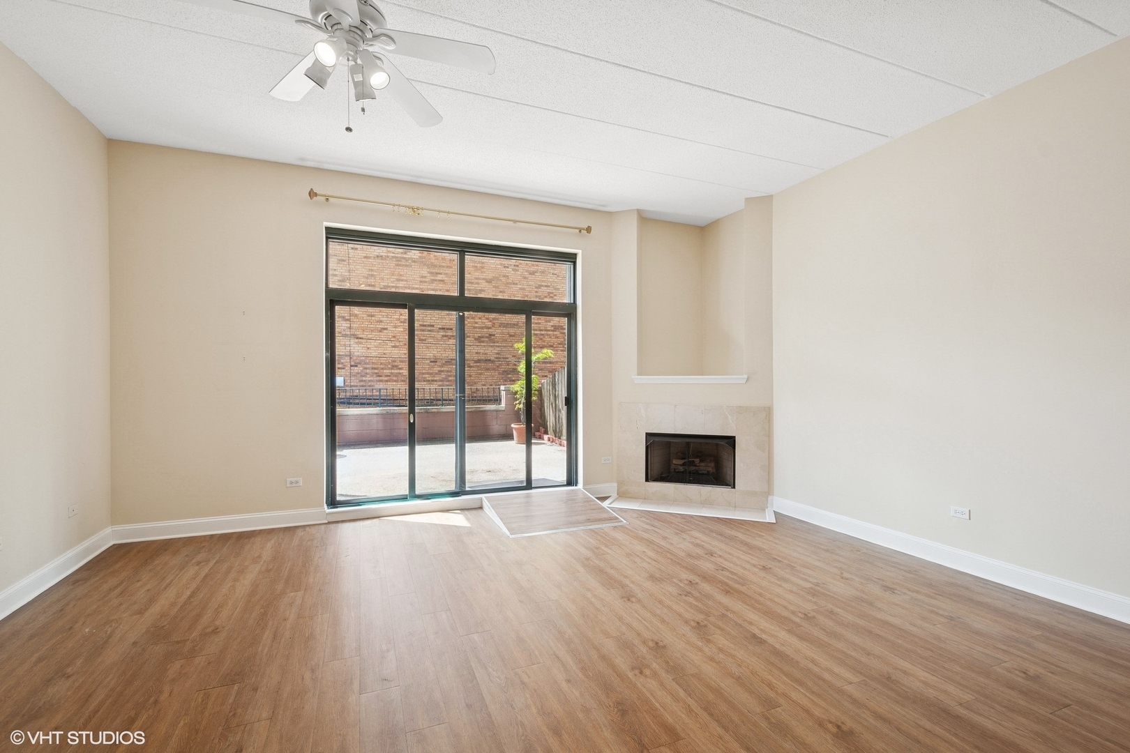 1301 West Washington Boulevard, Unit 203 Chicago, IL 60607 - Photo 2 of 15 wooden floor fireplace and windows in an empty room