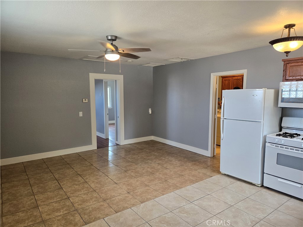 6467 Oak Hill Road, Unit B Oak Hills, CA 92344 - Photo 3 of 12 a view of a livingroom with a refrigerator a ceiling fan and cabinets