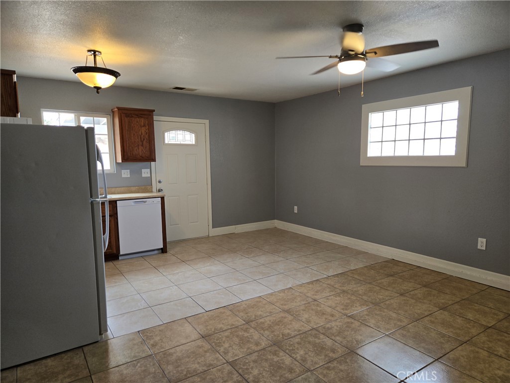 6467 Oak Hill Road, Unit B Oak Hills, CA 92344 - Photo 5 of 12 a view of a kitchen with a stove cabinets a ceiling fan and wooden floor