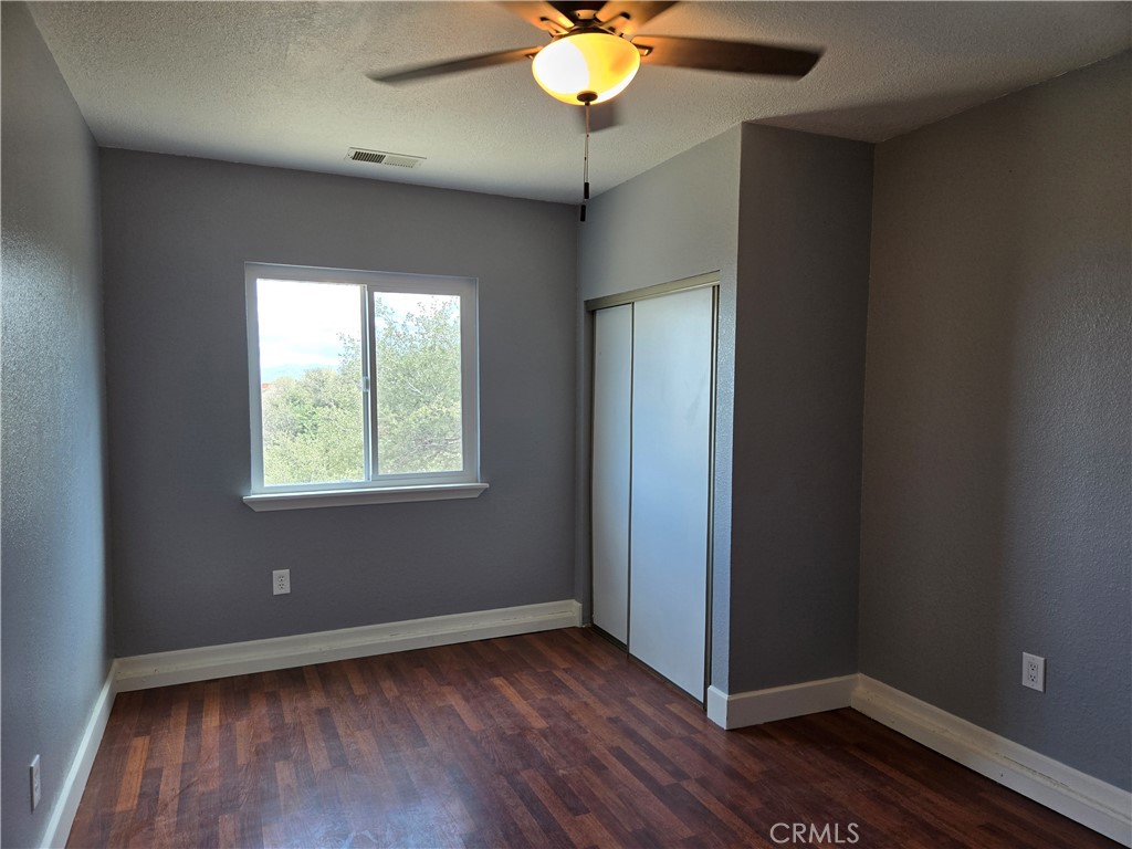 6467 Oak Hill Road, Unit B Oak Hills, CA 92344 - Photo 10 of 12 an empty room with wooden floor and windows