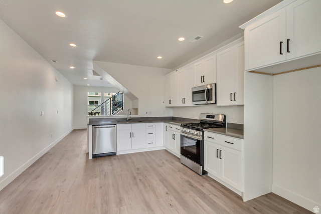 11013 South Freestone Road, Unit 117 South Jordan, UT 84009 - Photo 1 of 1 Kitchen with appliances with stainless steel finishes, white cabinetry, a peninsula, recessed lighting, and dark countertops