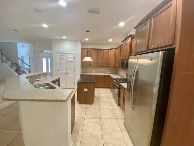 a kitchen with a refrigerator sink and cabinets