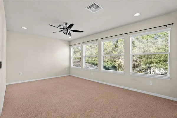 an empty room with a ceiling fan and a window