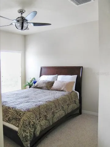 a bedroom with a bed and ceiling fan