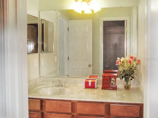 a bathroom with a granite countertop sink and a mirror