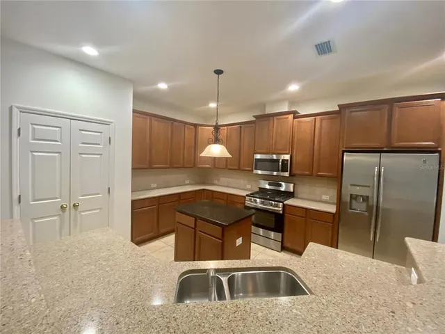 a kitchen with kitchen island a sink stainless steel appliances and cabinets