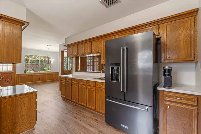 a kitchen with stainless steel appliances granite countertop a refrigerator and a stove top oven