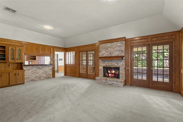 a view of an empty room with a fireplace and a window