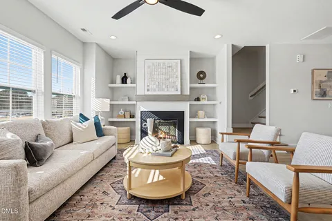 a kitchen with stainless steel appliances granite countertop a stove a sink a refrigerator and chairs with wooden floor