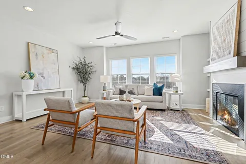a living room with furniture a large window and a fireplace