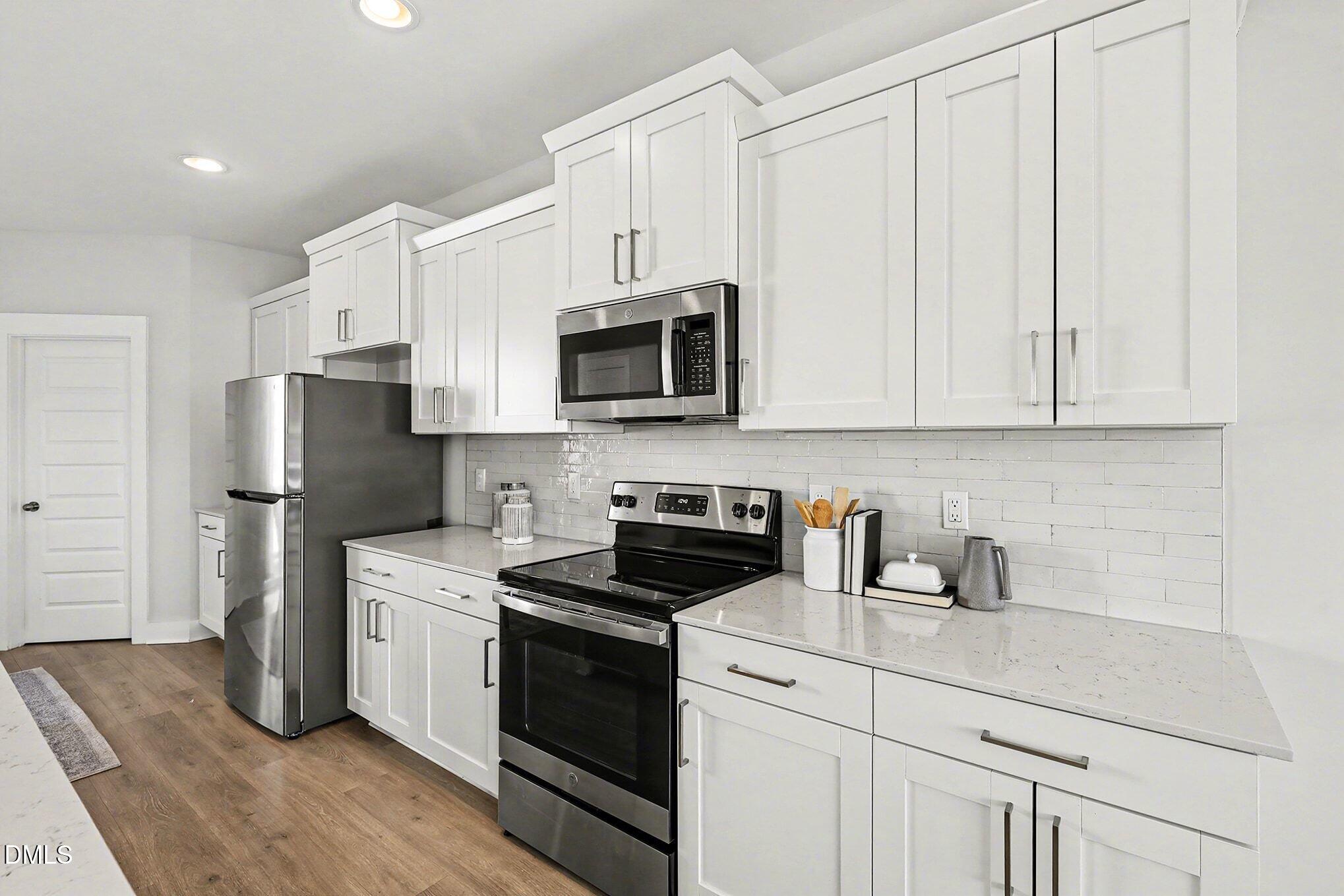8512 Silsbee Drive Raleigh, NC 27613 - Photo 19 of 42 a kitchen with stainless steel appliances white cabinets and a sink