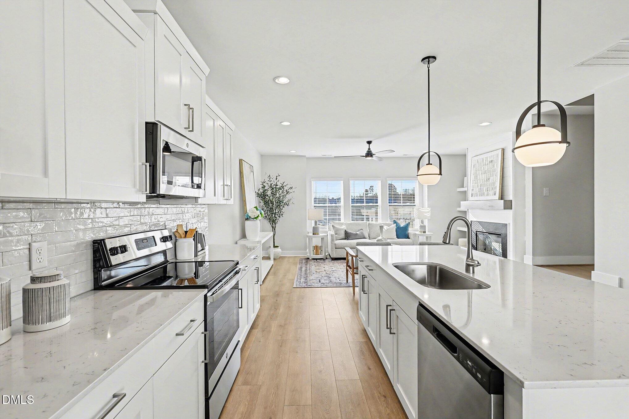8512 Silsbee Drive Raleigh, NC 27613 - Photo 20 of 42 a kitchen with stainless steel appliances granite countertop a sink a stove and a wooden floors