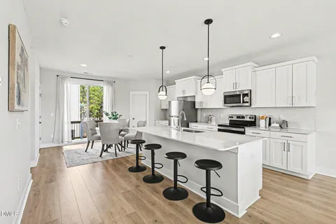 a kitchen with stainless steel appliances granite countertop a sink a stove and a wooden floors