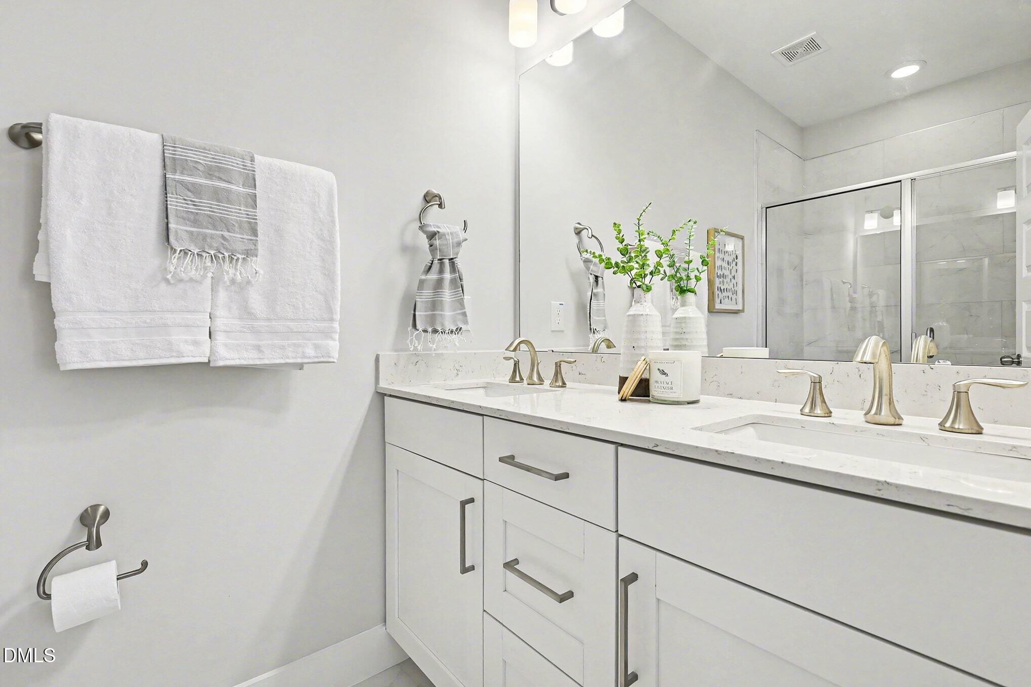 8512 Silsbee Drive Raleigh, NC 27613 - Photo 27 of 42 a bathroom with a double vanity sink mirror and