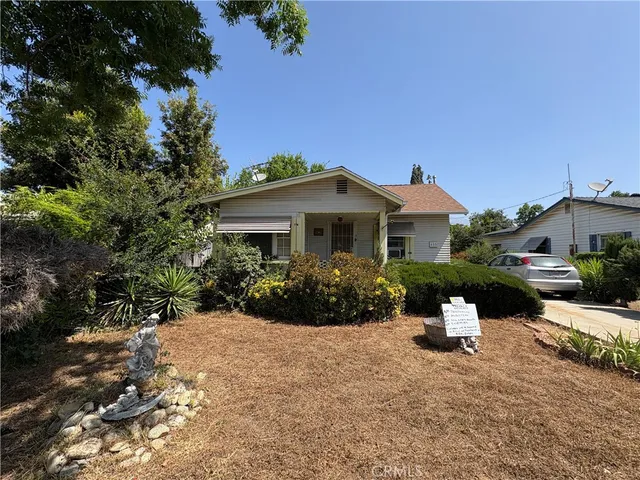 a front view of a house with a yard and a bench