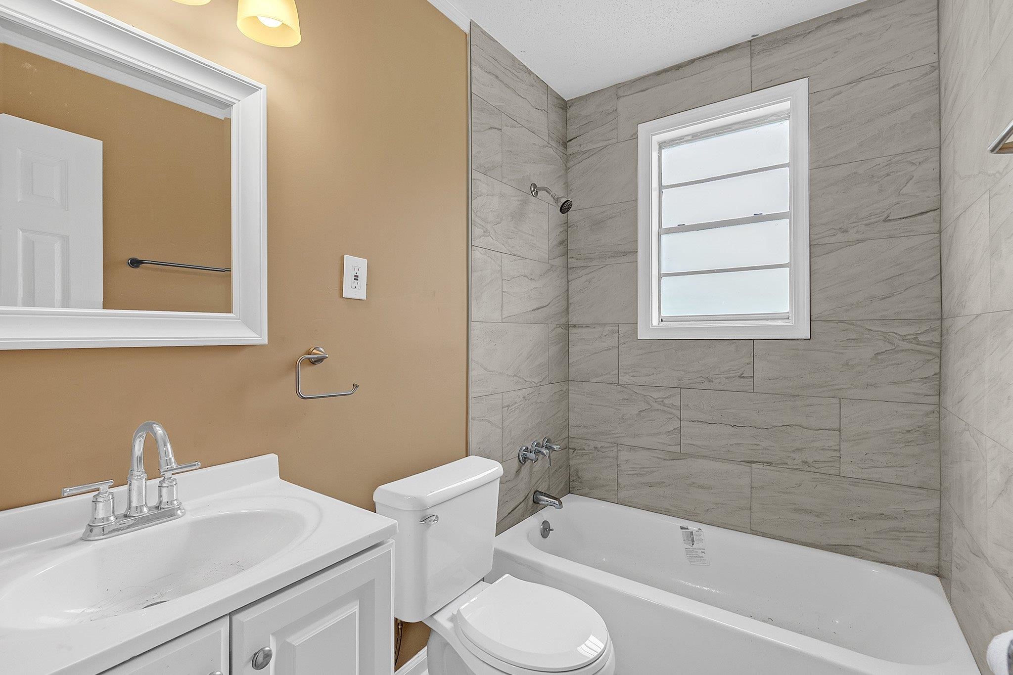3186 Alta Road Memphis, TN 38109 - Photo 8 of 14 Bathroom featuring a white vanity with integrated sink, chrome fixtures, and a framed mirror