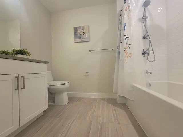 a bathroom with a white toilet and a shower