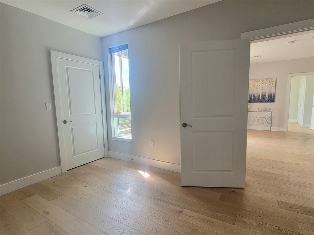 1650 Commonwealth Avenue, Unit 304A Boston, MA 02135 - Photo 19 of 26 an empty room with wooden floor and windows