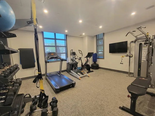 a room with gym equipment and a flat screen tv
