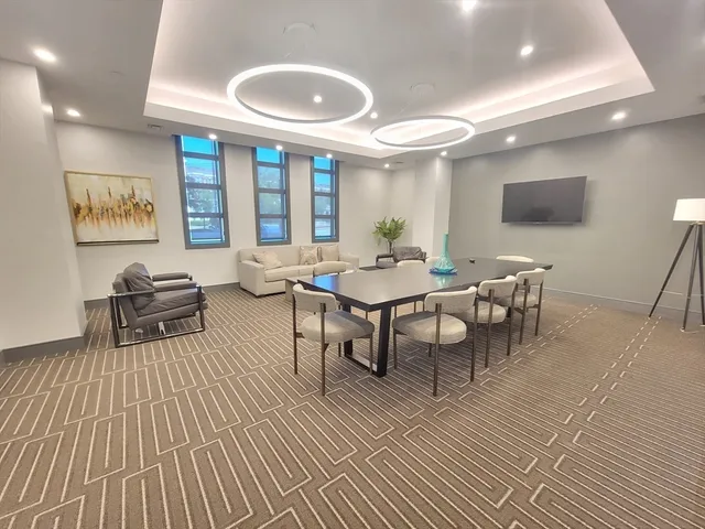 a living room with furniture a large window and dining table