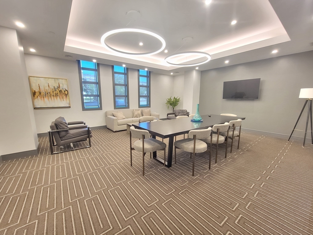 1650 Commonwealth Avenue, Unit 304A Boston, MA 02135 - Photo 5 of 26 a living room with furniture a large window and dining table