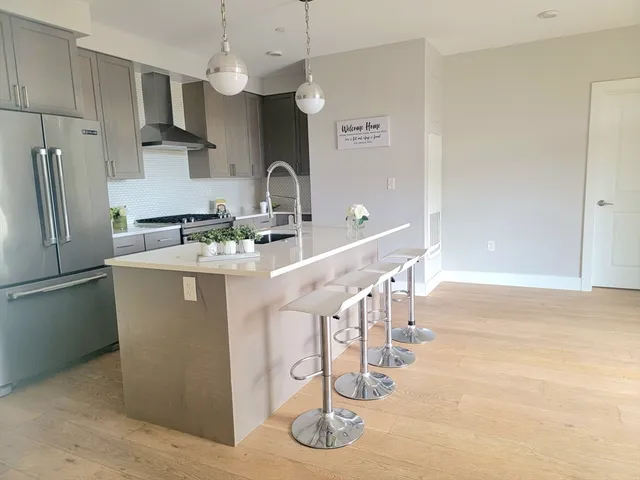 a kitchen with stainless steel appliances granite countertop a sink a stove and a refrigerator