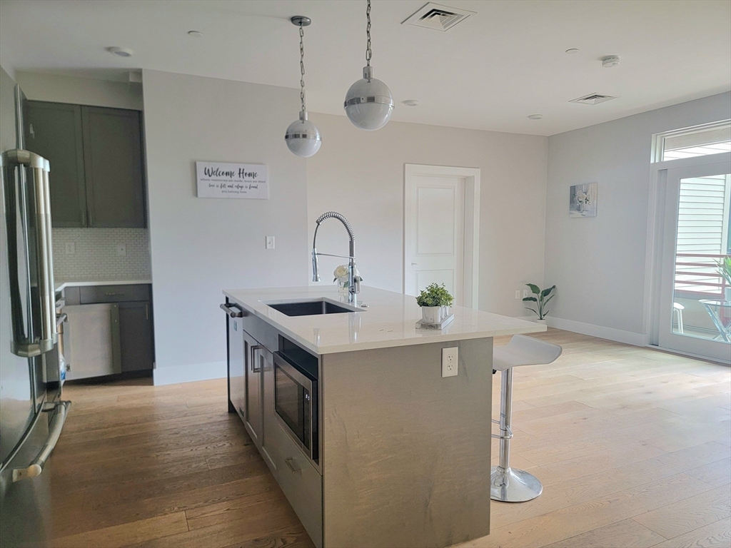 1650 Commonwealth Avenue, Unit 304A Boston, MA 02135 - Photo 9 of 26 a kitchen with stainless steel appliances a sink and a refrigerator
