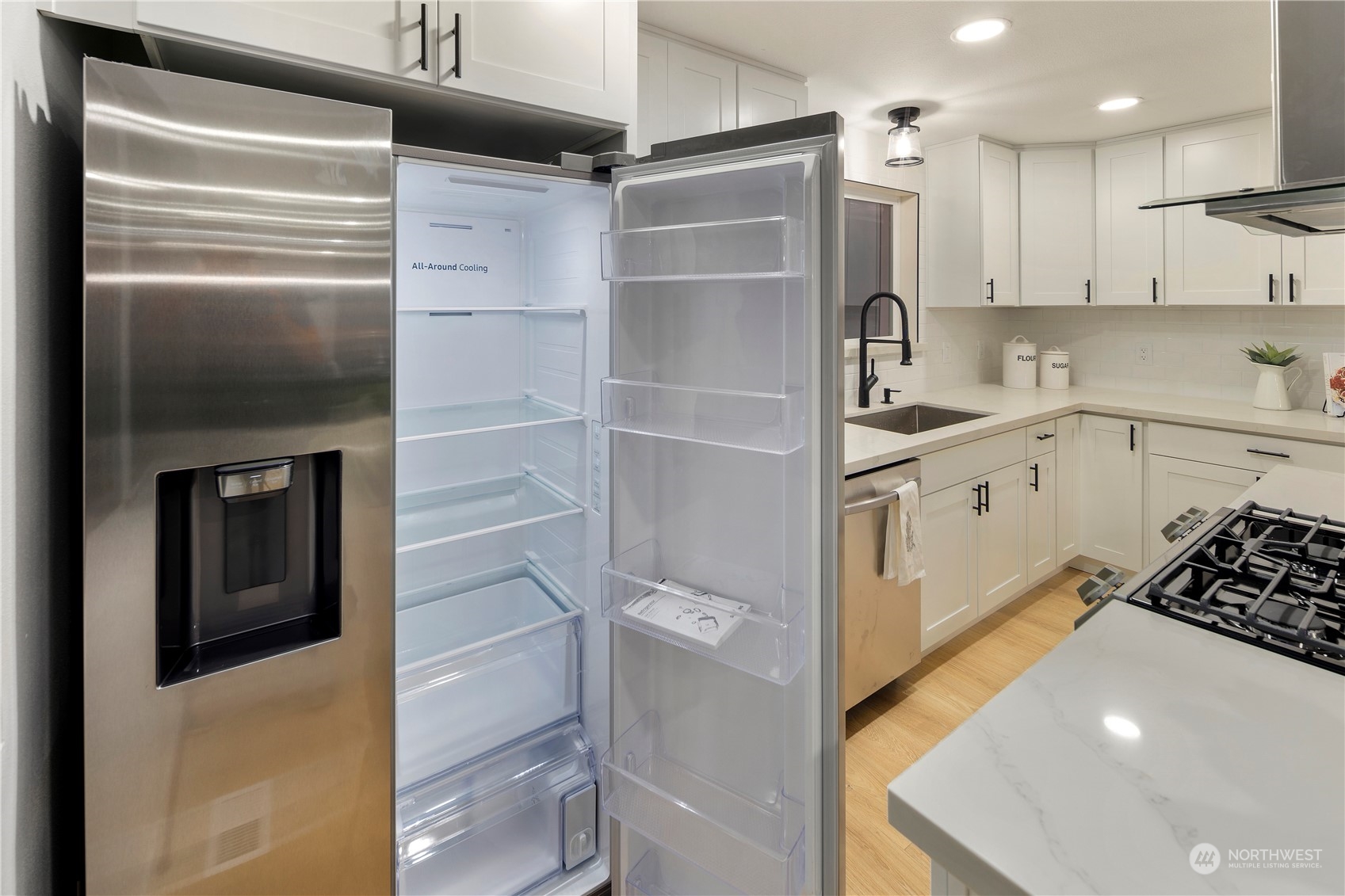 2823 South Bateman Street Seattle, WA 98108 - Photo 15 of 39 a kitchen with a refrigerator and white cabinets