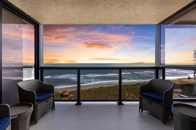 a living room with hardwood floor and large windows