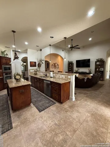 a large white kitchen with a large island in the center