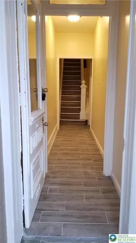 a view of a hallway with wooden floor and staircase
