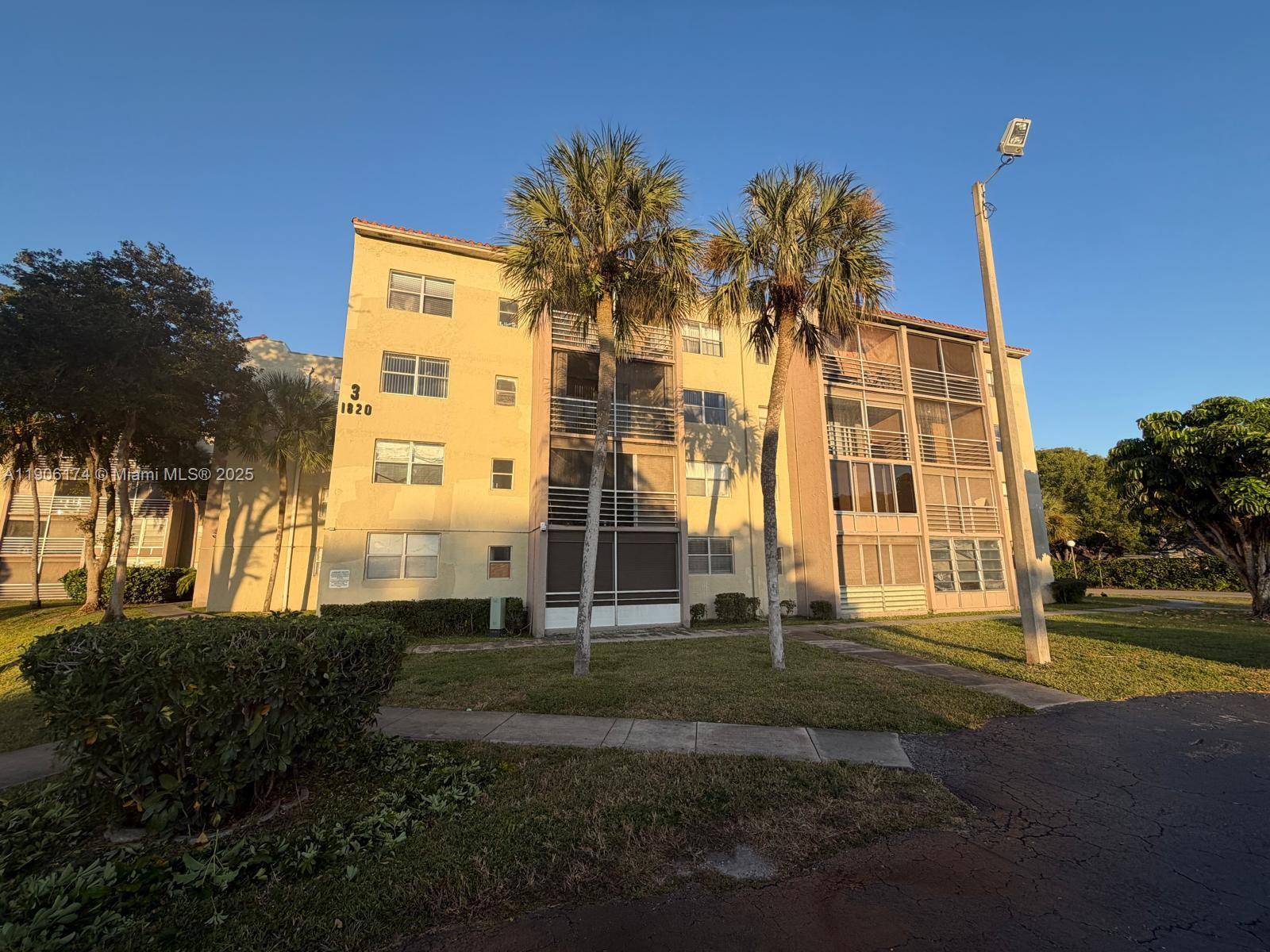 1820 Southwest 81st Avenue, Unit 3107 North Lauderdale, FL 33068 - Photo 20 of 25 a front view of a residential apartment building with a yard