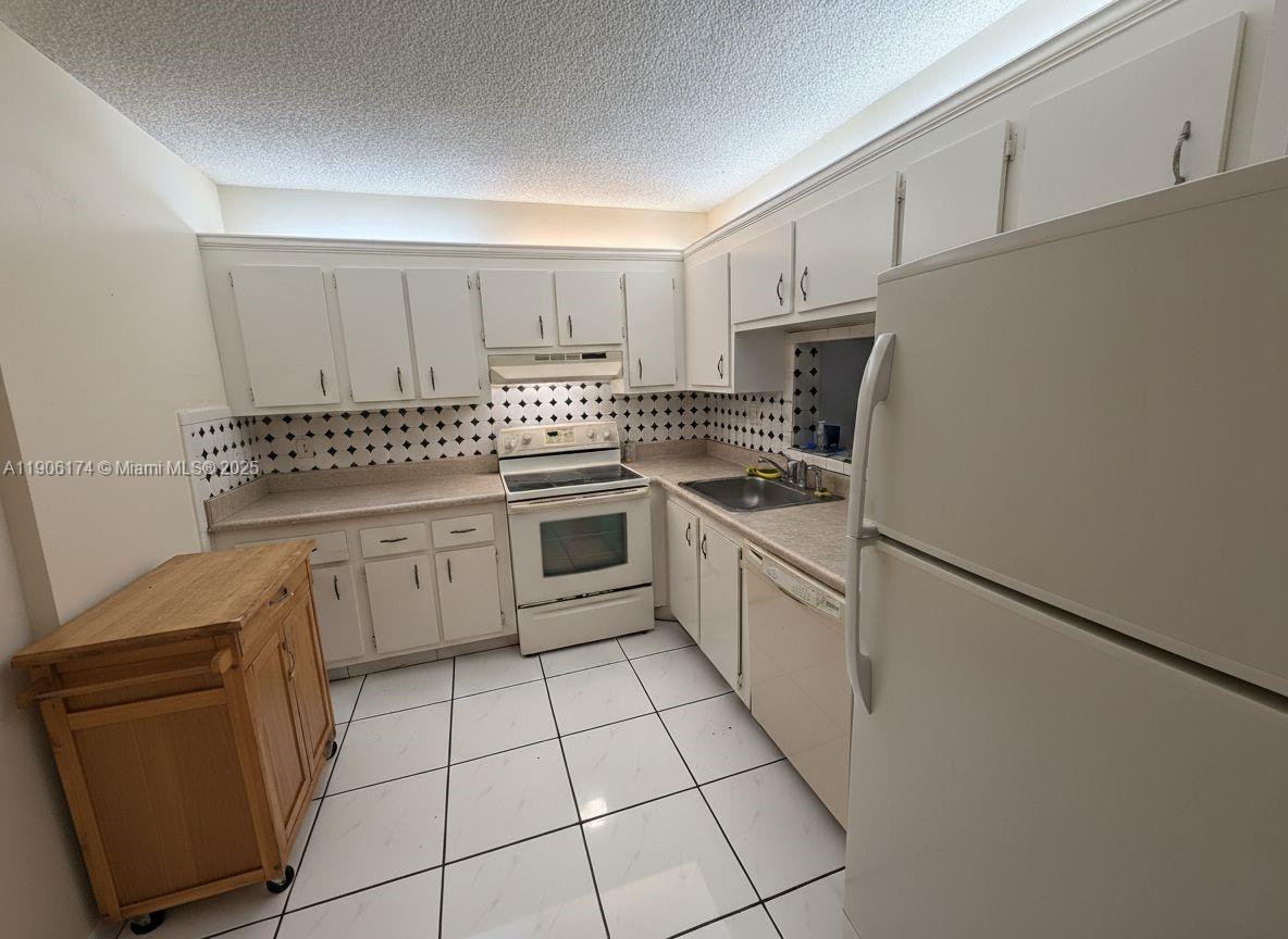 1820 Southwest 81st Avenue, Unit 3107 North Lauderdale, FL 33068 - Photo 10 of 25 a kitchen with a stove top oven sink and cabinets