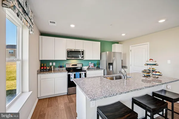 a kitchen with stainless steel appliances granite countertop a sink refrigerator and microwave