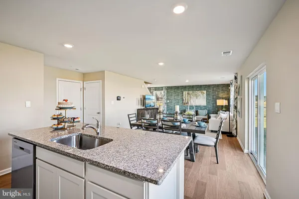 a living room with stainless steel appliances granite countertop sink and couch