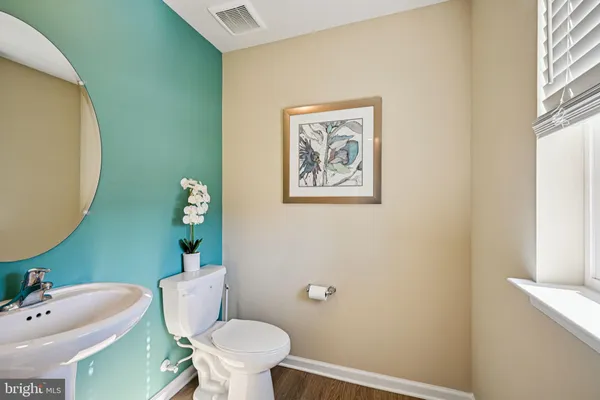 a white toilet sitting next to a bathroom sink and a mirror