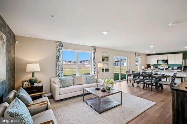 a living room with furniture and view of kitchen