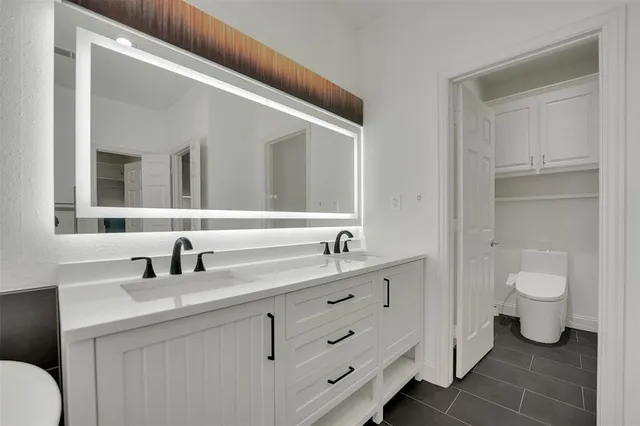 a bathroom with a toilet a sink and mirror