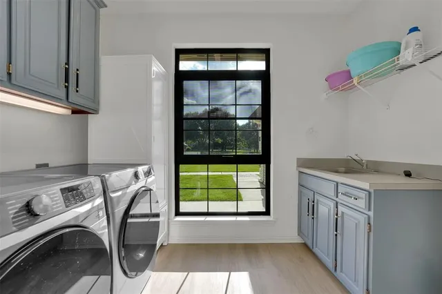 a utility room with cabinets washer and dryer