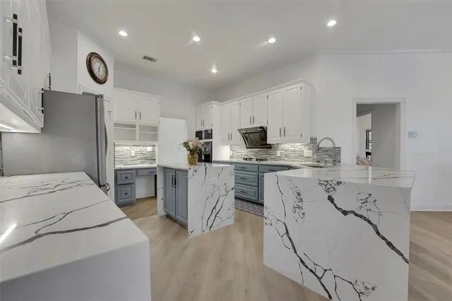 a kitchen with white cabinets and stainless steel appliances