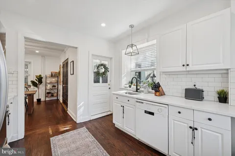 a kitchen with white cabinets and sink