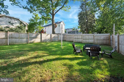 a view of a backyard with table and chairs and a large tree