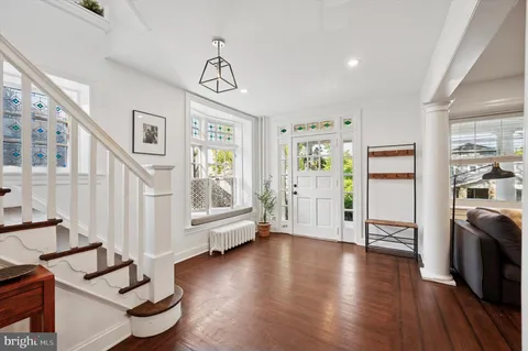 a view of a livingroom with wooden floor and furniture