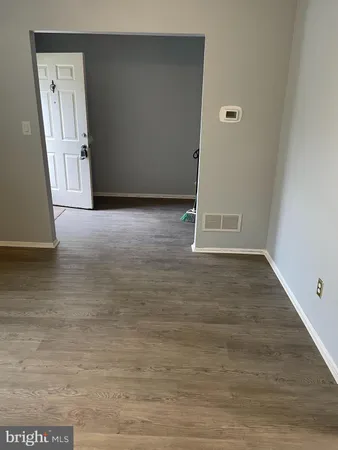 an empty room with wooden floor and entrance