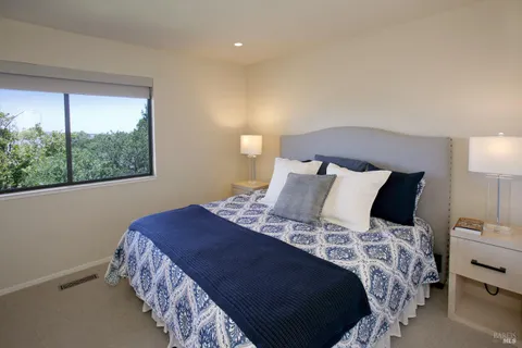 a bedroom with a large bed and a lamp next to a window