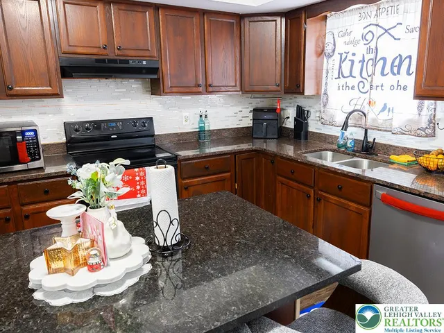 a kitchen with stainless steel appliances granite countertop a sink dishwasher stove and cabinets
