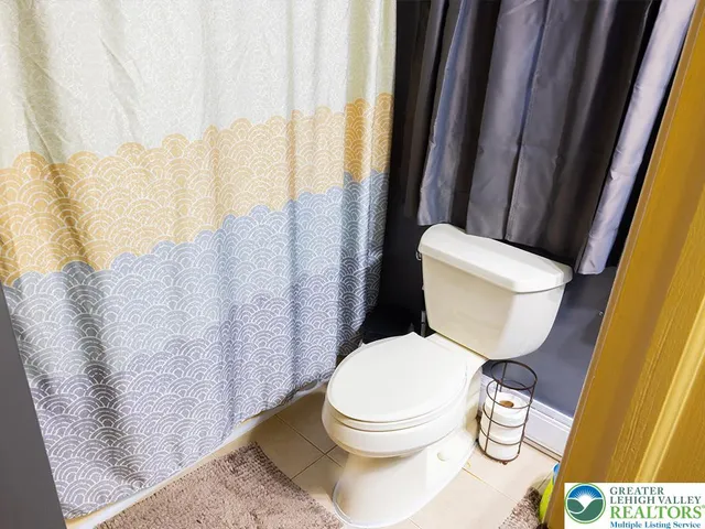 a white toilet sitting next to a bathroom sink and a shower