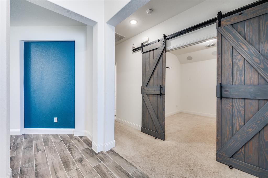 7025 Trailhead Street Little Elm, TX 76227 - Photo 3 of 25 a view of an empty room with wooden floor and a window