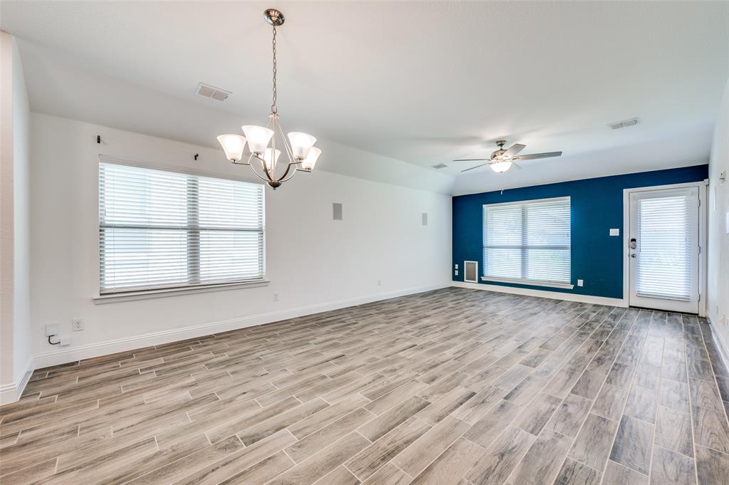 7025 Trailhead Street Little Elm, TX 76227 - Photo 5 of 25 a view of a livingroom with a chandelier fan and windows